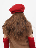 Women's red wool beret back view showing flat crown drape and hair length compatibility