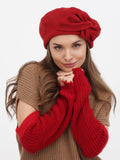 Women's red wool beret with handcrafted fabric flower close-up, front profile view showing flower detail and wool texture