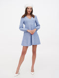 White linen beret hat on woman in blue linen mini dress, full length front view