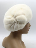 Women's white mink fur beret with large handcrafted white mink flower side profile view showing layered petal structure and luminous white fur