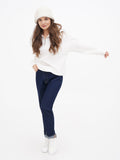 Full-length photo of woman in white hoodie and navy trousers wearing ivory cloche hat