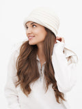Woman looking over shoulder smiling, wearing ivory wool cloche hat