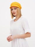 Woman wearing yellow linen Breton cap, summer outdoor portrait
