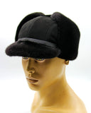 Man wearing black mink and suede ushanka bill cap earflaps up