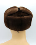 Man wearing pastel mink fur hat ushanka outdoors winter setting