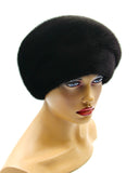 Women's black mink fur beret with gathered tucks front three-quarter view showing ridged tuck texture and deep black fur