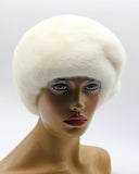 Women's white mink fur beret with gathered tucks side profile view on model showing textured crown ridges and white fur depth